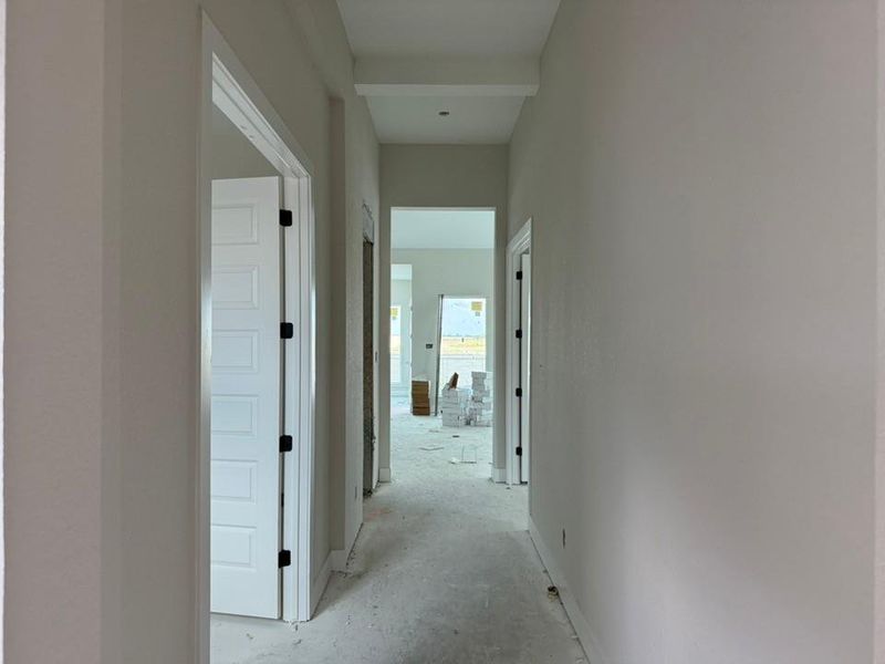 Corridor with unfinished concrete flooring and baseboards