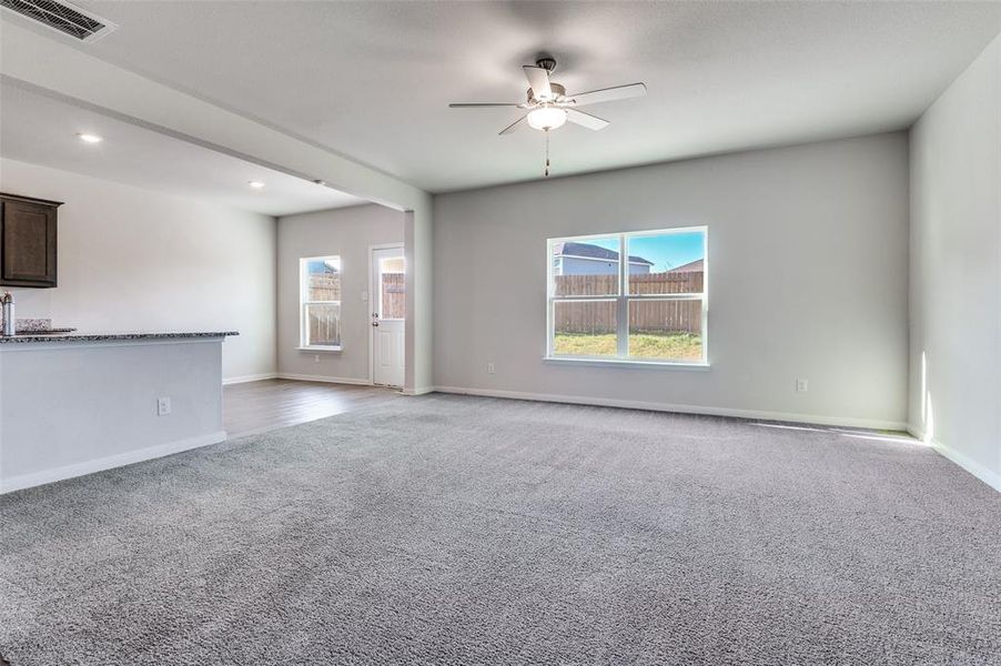 Unfurnished living room featuring a ceiling fan, carpet flooring, and recessed lighting