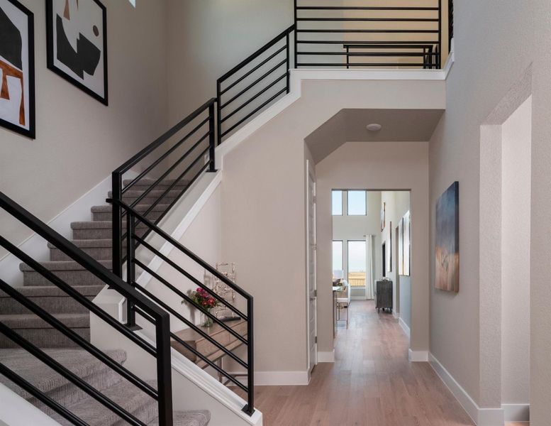 Stairs with a towering ceiling and wood finished floors