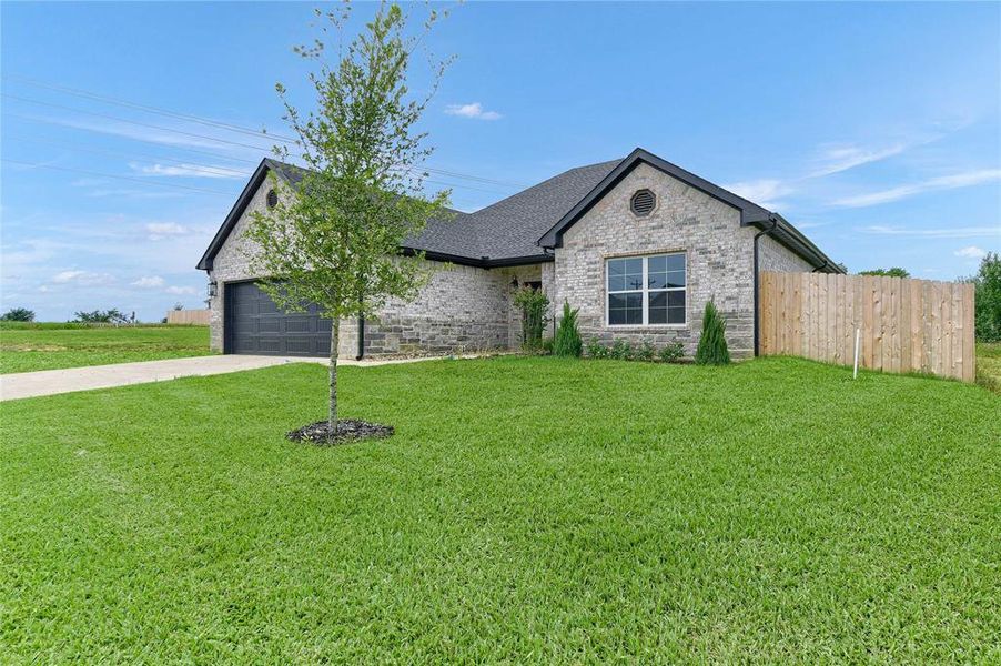 View of front of property featuring a garage and a front yard