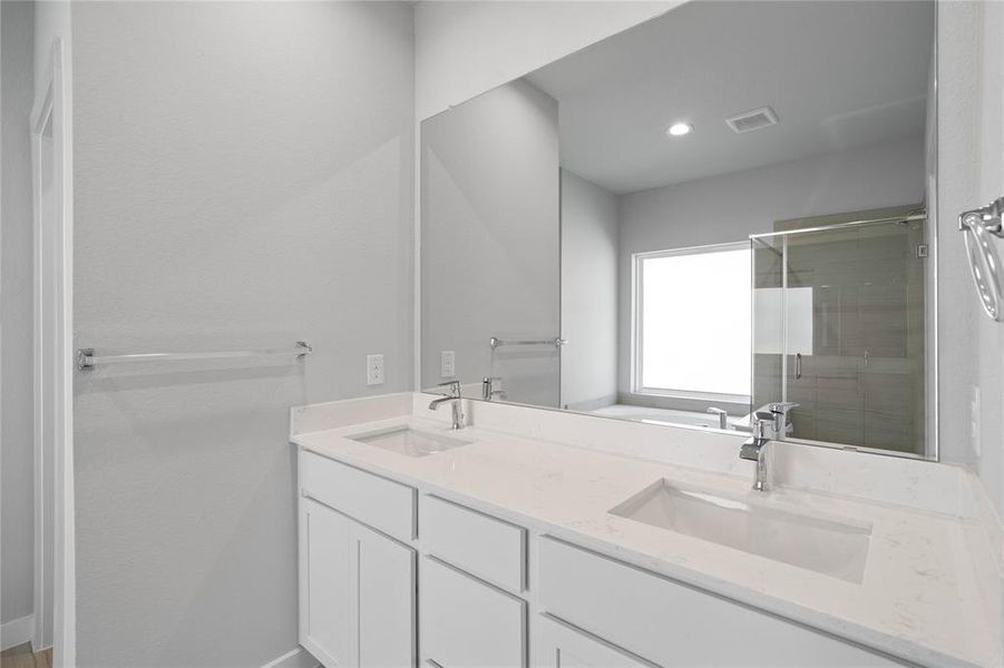 This primary bathroom is definitely move-in ready! Featuring light stained cabinets with light countertops, spacious walk-in closet with shelving, high ceilings, custom paint, sleek modern finishes.