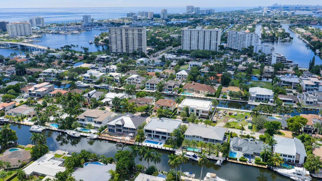 A vibrant neighborhood scene showing waterfront homes leading toward the Fort Lauderdale coastline and ocean horizon. A vibrant neighborhood scene showing waterfront homes leading toward the Fort Lauderdale coastline and ocean horizon.