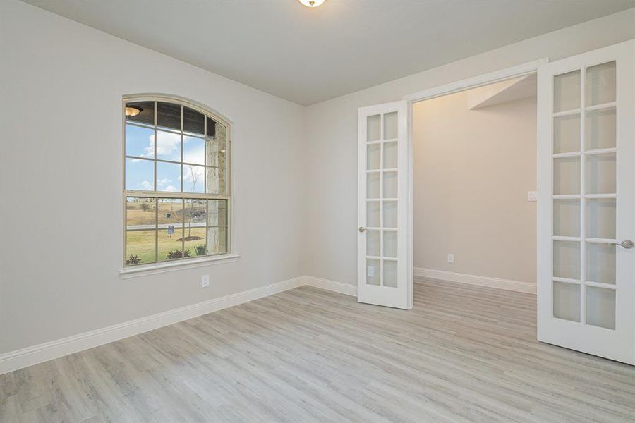 Empty room featuring light hardwood / wood-style floors and french doors