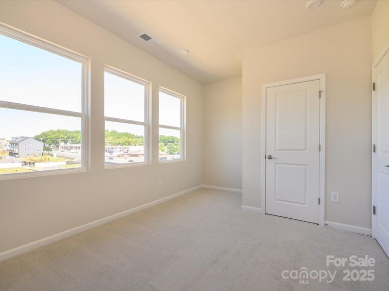 Secondary bedroom with wall of windows to open up the space.