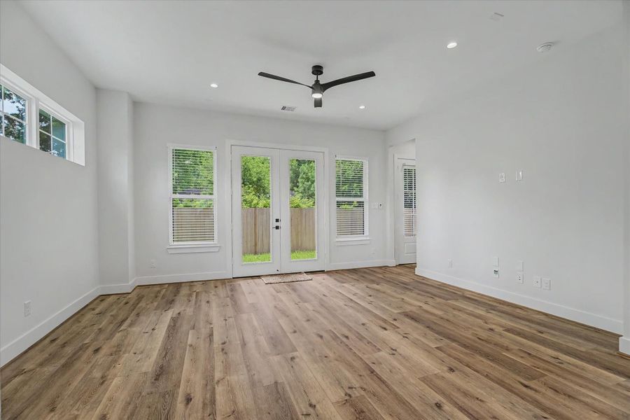 Spacious living room featuring French doors that open directly to the backyard. The room is equipped with TV outlets and is pre-wired for both alarm and stereo systems.