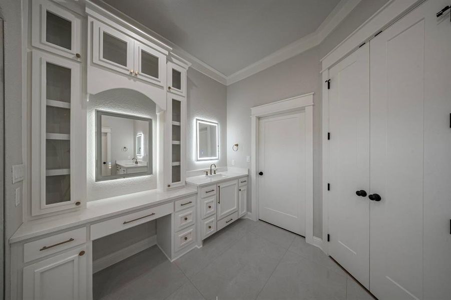 Bathroom featuring vanity, crown molding, and light tile patterned floors Bathroom featuring vanity, crown molding, and light tile patterned floors