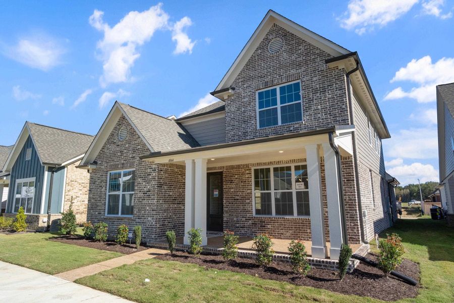 View of front facade with brick siding, a front yard, covered porch, and roof with shingles View of front facade with brick siding, a front yard, covered porch, and roof with shingles
