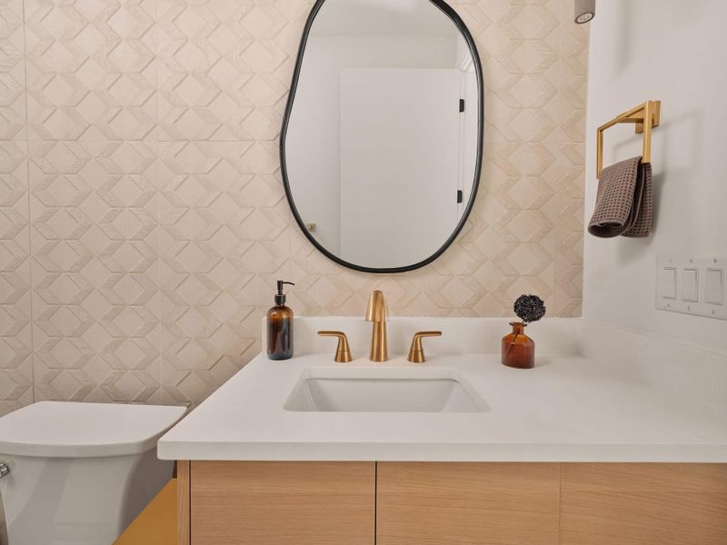 Half bath with vanity and tile walls