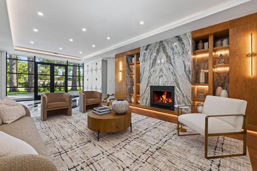 Additional living-room perspective highlights the fireplace, custom built-ins and connection to the outdoors.