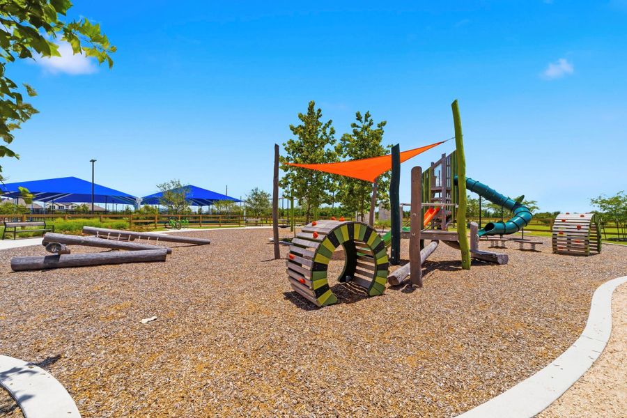 Adventure playground with climbing features and shaded play areas for all ages.