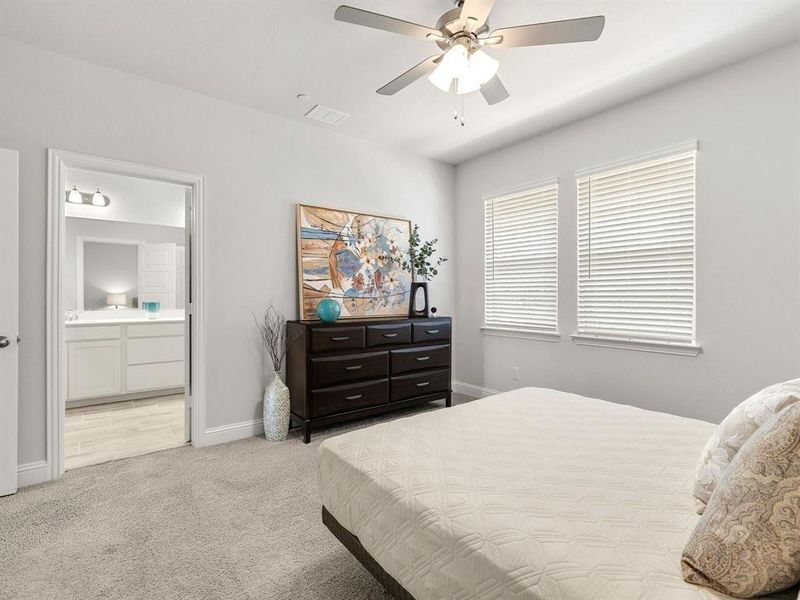 Large windows line the primary bedroom, filling the sleeping quarters with lovely afternoon sunlight and scenic views.