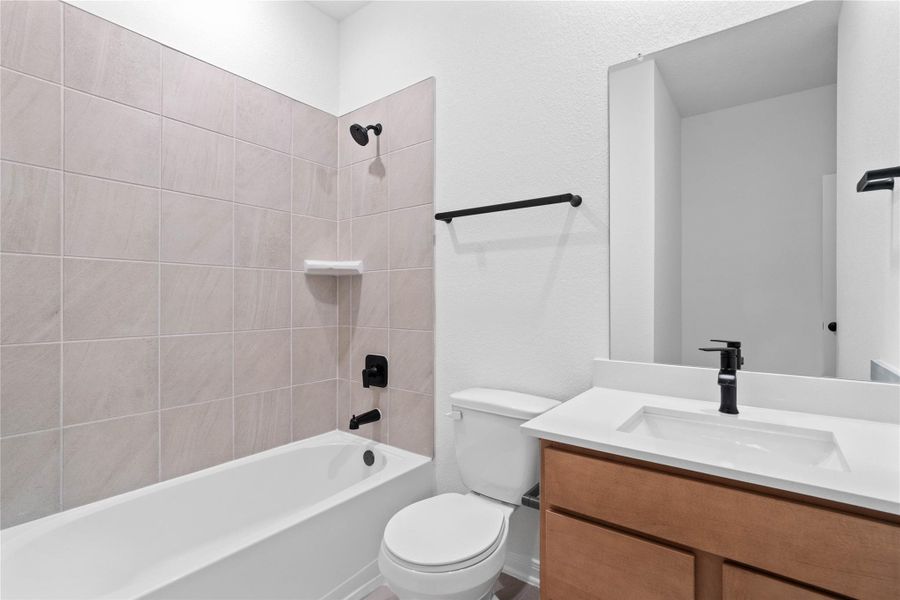 The secondary bathroom showcases tile flooring, a bath/shower combo with Daltile tile surround, a vanity with stunning light countertop, a mirror, sleek fixtures, and contemporary finishes throughout. The secondary bathroom showcases tile flooring, a bath/shower combo with Daltile tile surround, a vanity with stunning light countertop, a mirror, sleek fixtures, and contemporary finishes throughout.