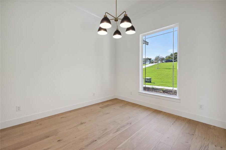 Unfurnished dining area with light wood-type flooring, a chandelier, and crown molding