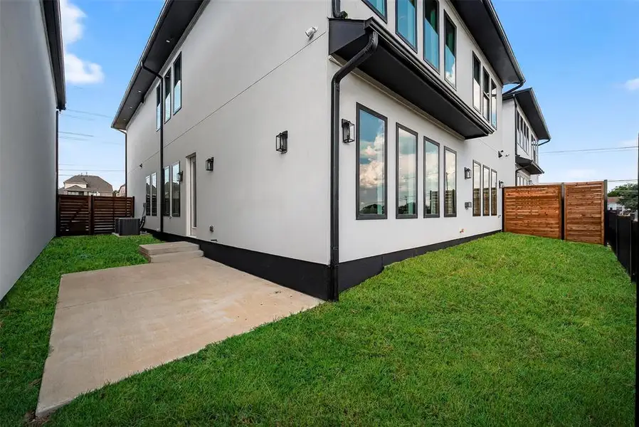 View of side of property with a fenced backyard and stucco siding