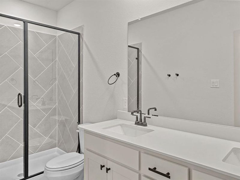 Bathroom featuring toilet, a shower with shower door, and vanity