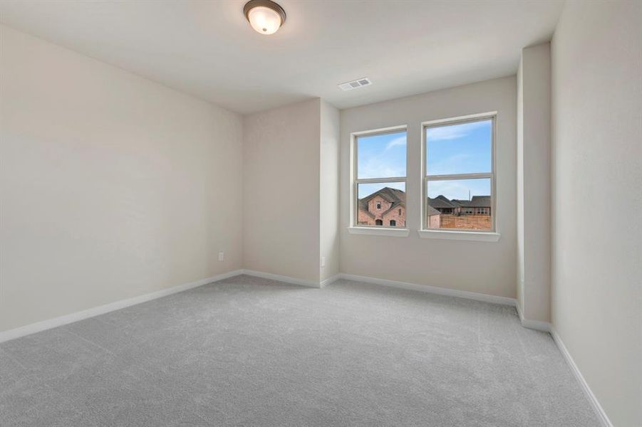 Spare room featuring light carpet and baseboards