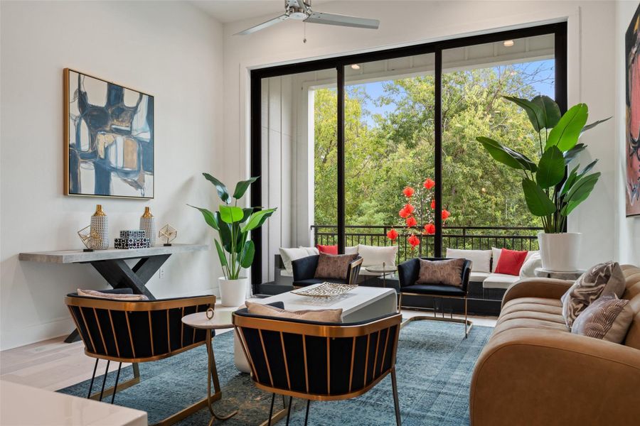 Sitting room with wood finished floors, plenty of natural light, and a ceiling fan