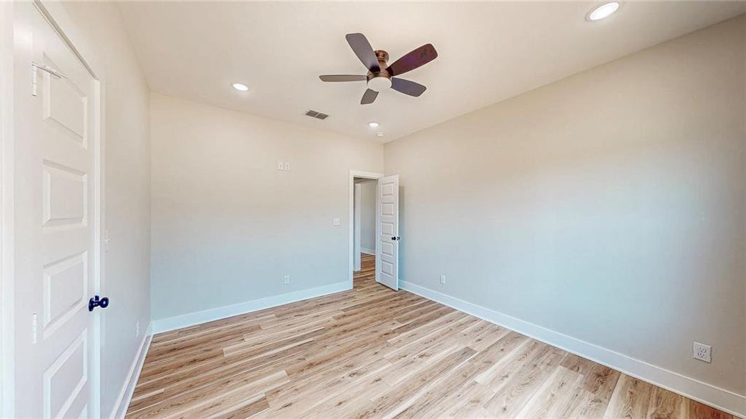 Empty room with ceiling fan, light wood-style flooring, and recessed lighting Empty room with ceiling fan, light wood-style flooring, and recessed lighting