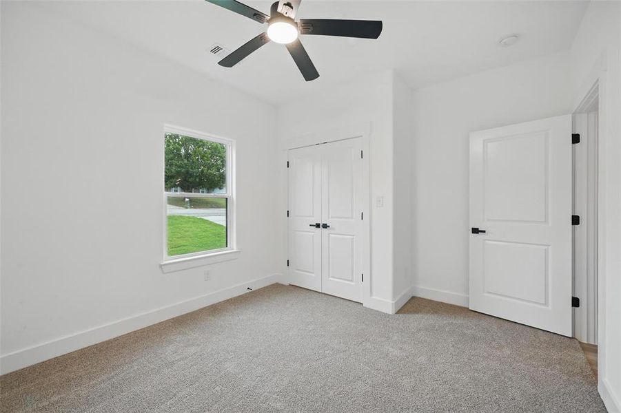 Unfurnished bedroom featuring carpet floors, baseboards, ceiling fan, and a closet