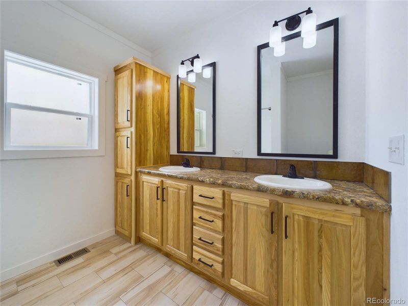 Bathroom tasteful backsplash, and double vanity, linen cabinet, Obscure glass window...