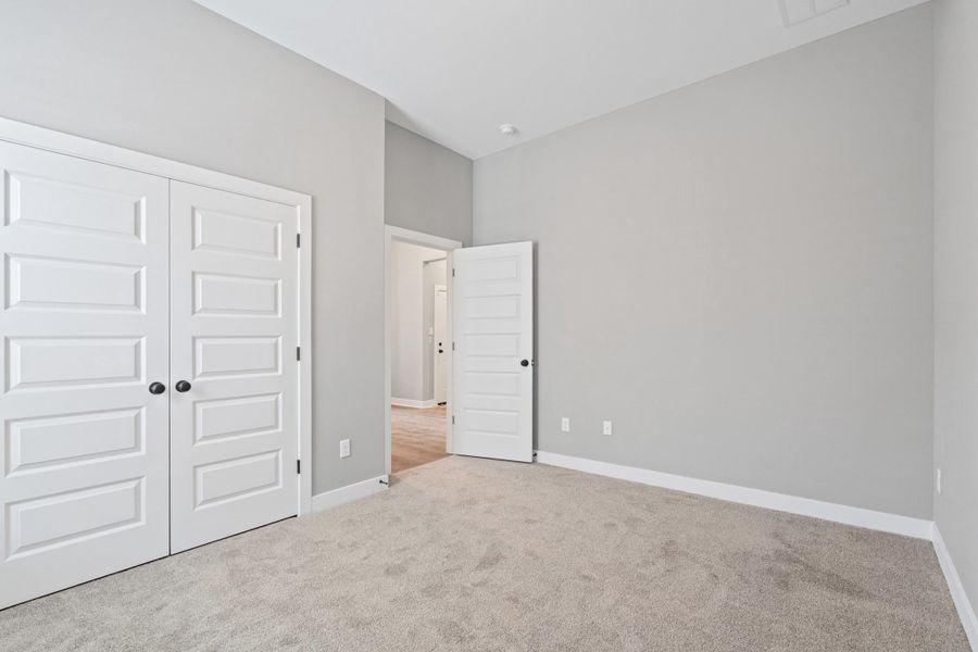 Unfurnished bedroom featuring light colored carpet and a closet