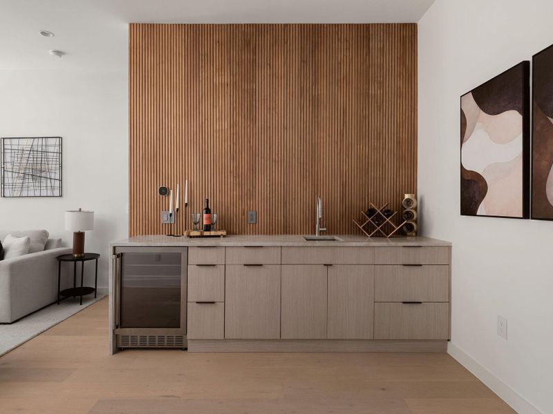 An elegant wet bar features custom wood slat paneling.