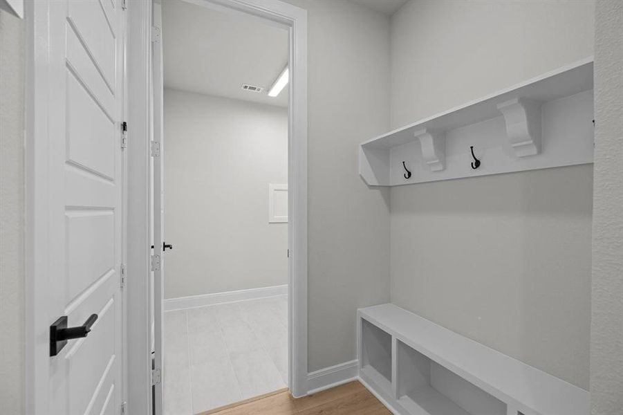 Built-in mudroom bench with cubby storage and upper shelf featuring three coat hooks Built-in mudroom bench with cubby storage and upper shelf featuring three coat hooks