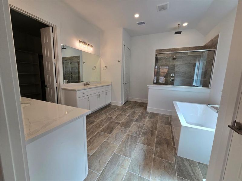 The owner's bath of your dreams features his and her vanities, a freestanding tub and spacious walk in shower!