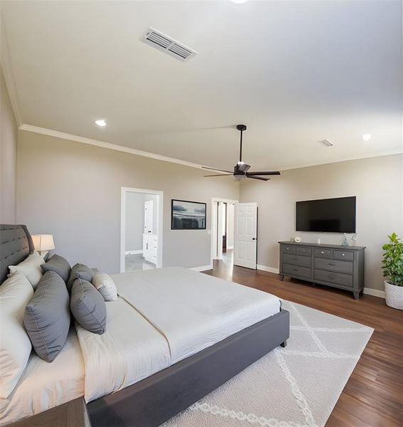 Bedroom with crown molding, dark wood-style floors, recessed lighting, and a ceiling fan Bedroom with crown molding, dark wood-style floors, recessed lighting, and a ceiling fan