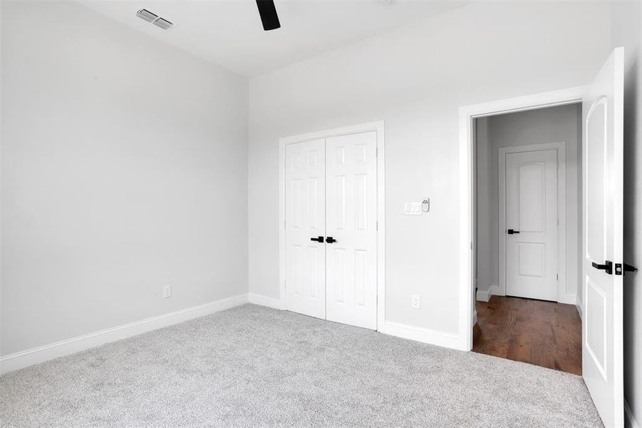 Unfurnished bedroom featuring a closet, carpet floors, and ceiling fan