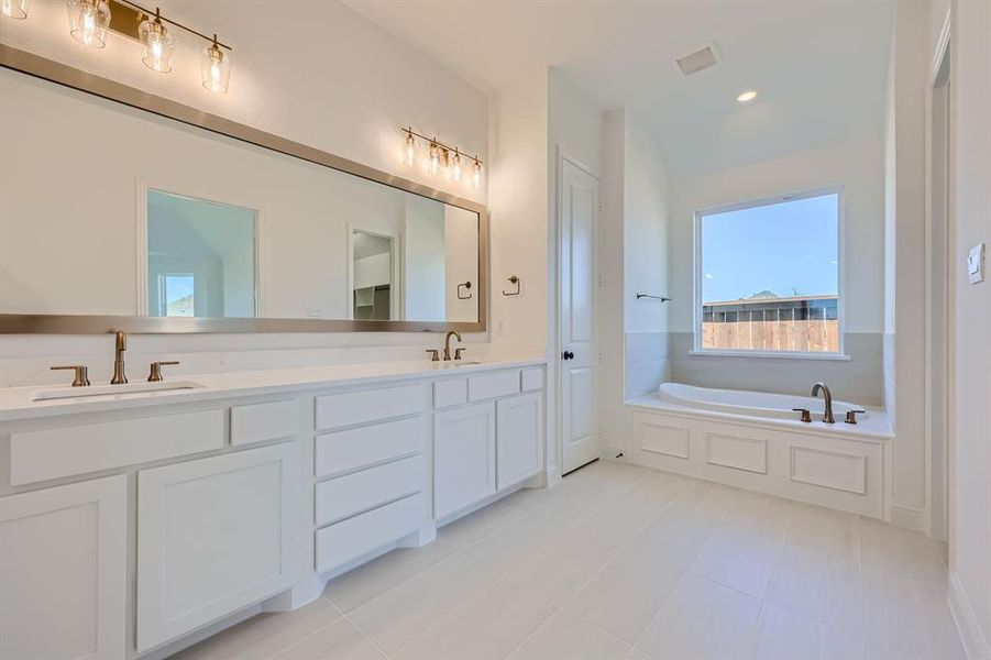 Bathroom featuring a tub to relax in and vanity