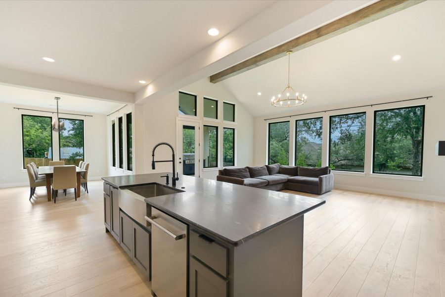 An open-concept living space boasts high ceilings, abundant natural light, and seamless flow from kitchen to dining.