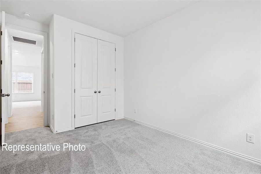 Neutral-toned room featuring a double-door closet with panel detailing and spherical hardware