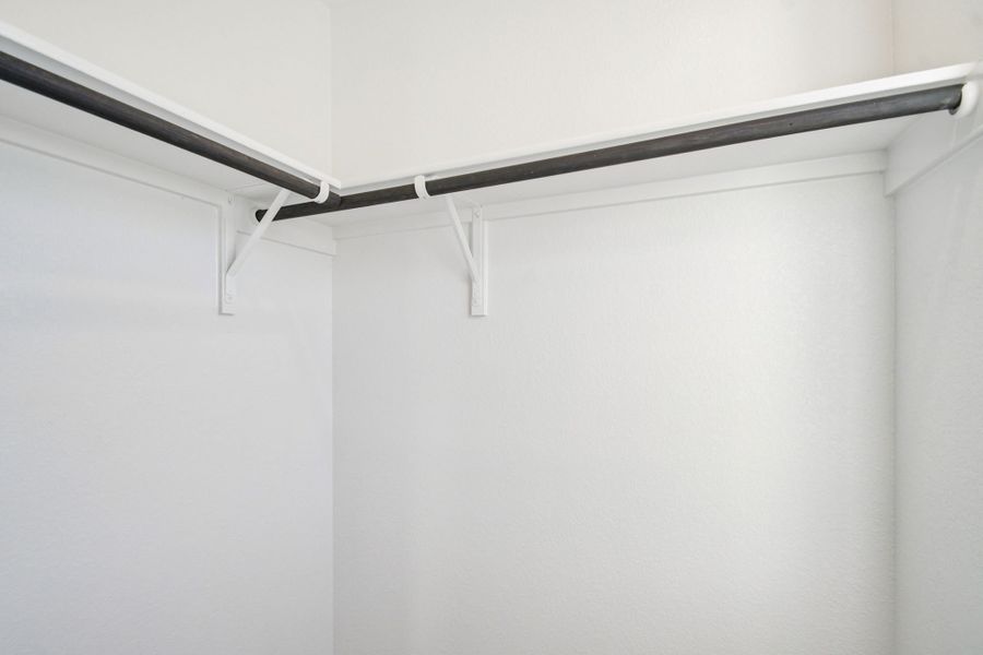 A white wall with a metal bar.
