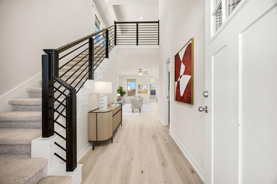 The stunning two-story entryway offers a grand, modern welcome into the home. This bright space immediately captures attention with its soaring ceilings and contemporary design elements. *Virtually Staged The stunning two-story entryway offers a grand, modern welcome into the home. This bright space immediately captures attention with its soaring ceilings and contemporary design elements. *Virtually Staged