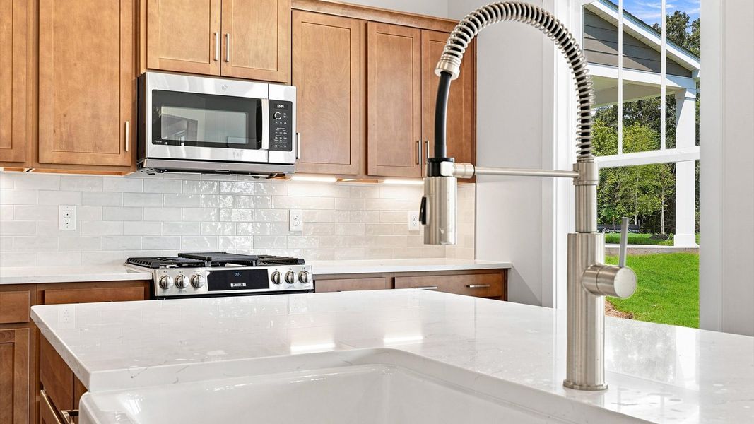 Superior kitchen with quartz countertops, pendant lighting, and a generously sized island