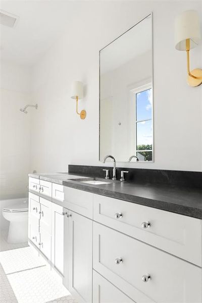 Bathroom featuring toilet, walk in shower, and vanity