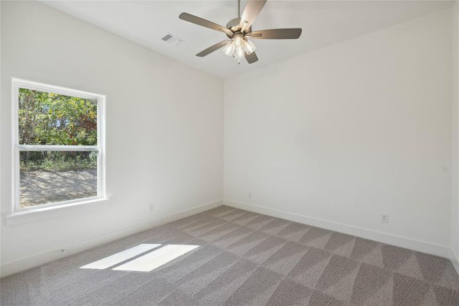 Carpeted spare room with ceiling fan