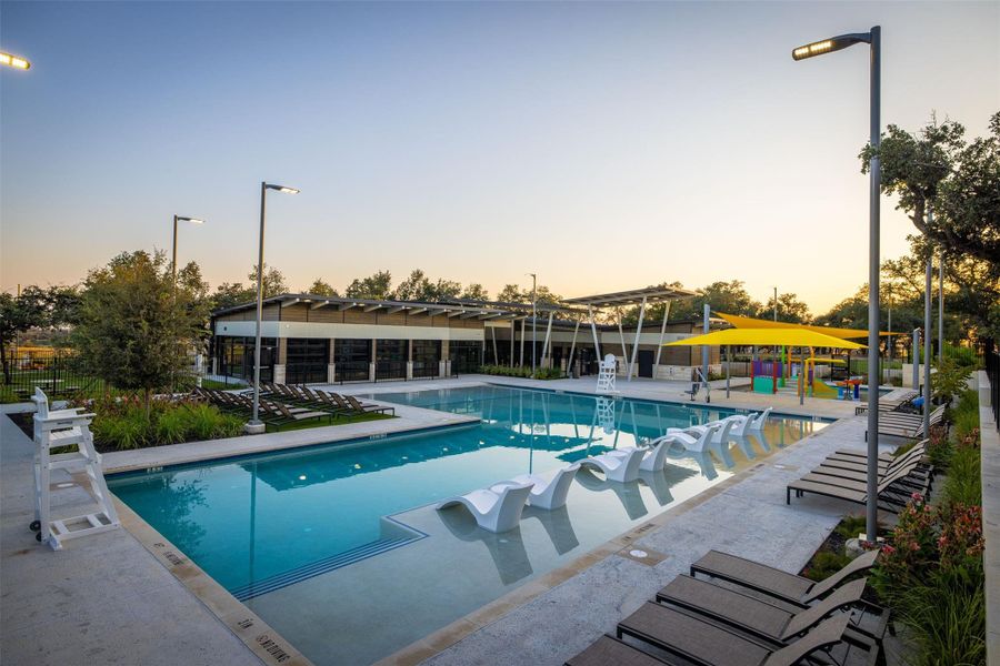 Pool at dusk with a patio and a pergola