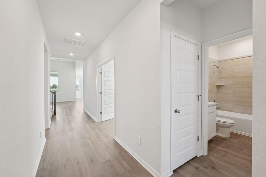 Corridor featuring light wood finished floors and recessed lighting