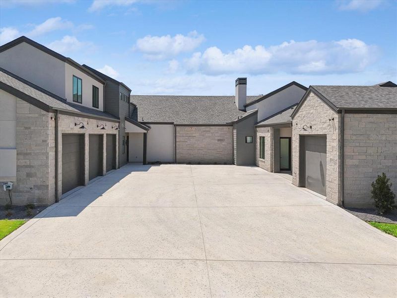 The garages offer single bay doors with exterior lighting above each bay.