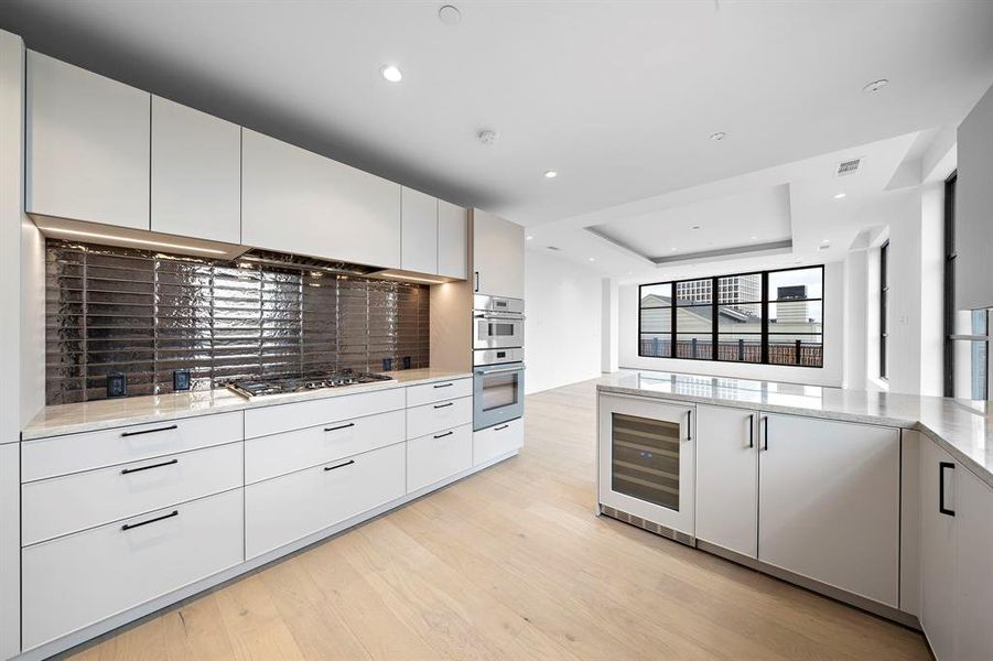 Enjoy the gourmet kitchen featuring sleek white Eggermans cabinetry, complemented by upscale finishes & soft close drawers. The gas cooktop serves as the centerpiece of this well-appointed kitchen.