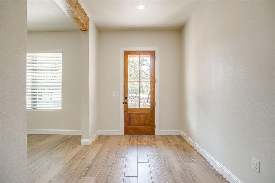 Entryway with light wood finished floors and beamed ceiling Entryway with light wood finished floors and beamed ceiling