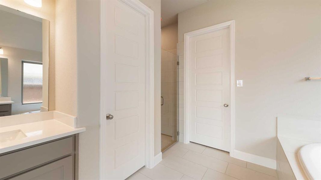 Bathroom with vanity, shower with separate bathtub, and tile patterned flooring