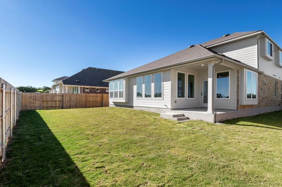 Rear view of house with a patio, a fenced backyard, and a shingled roof