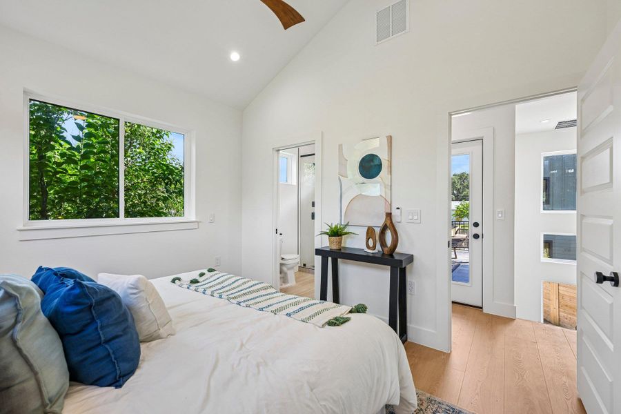 Natural light floods this inviting bedroom, highlighting the smooth wood look floors and vaulted ceilings. Natural light floods this inviting bedroom, highlighting the smooth wood look floors and vaulted ceilings.