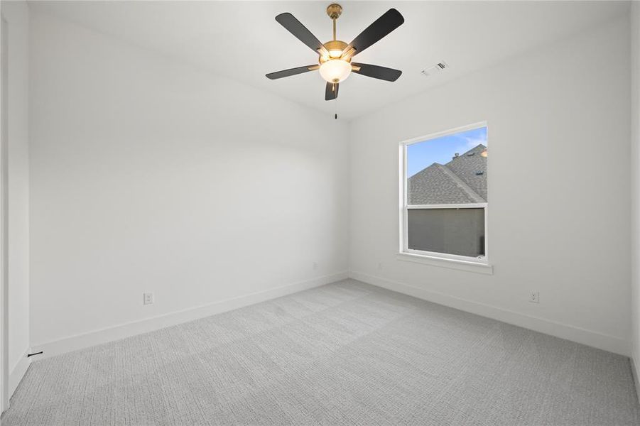 Unfurnished room with light colored carpet and a ceiling fan