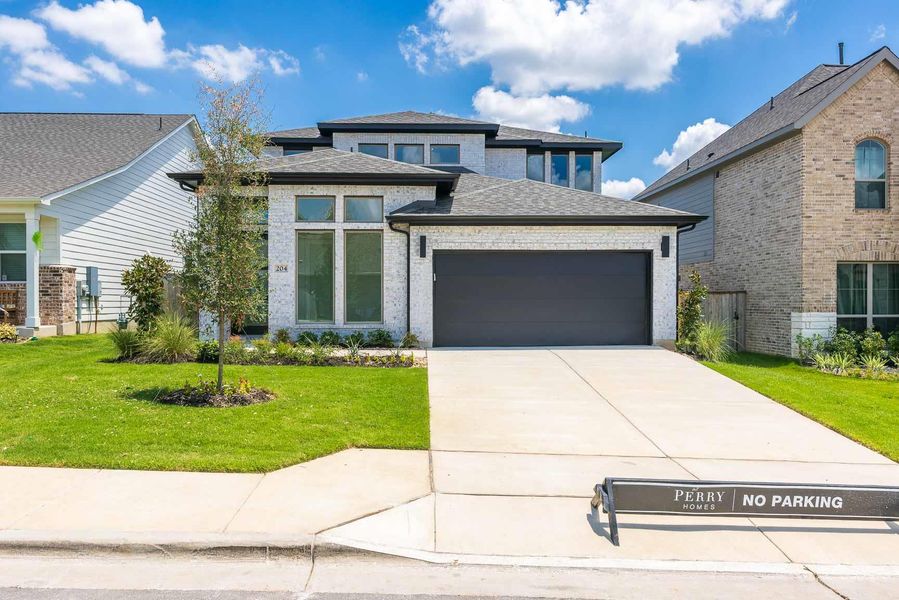 Prairie-style home with a garage, brick siding, driveway, and a front yard Prairie-style home with a garage, brick siding, driveway, and a front yard