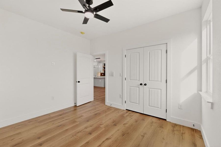 Unfurnished bedroom with light wood-type flooring, ceiling fan, and a closet Unfurnished bedroom with light wood-type flooring, ceiling fan, and a closet