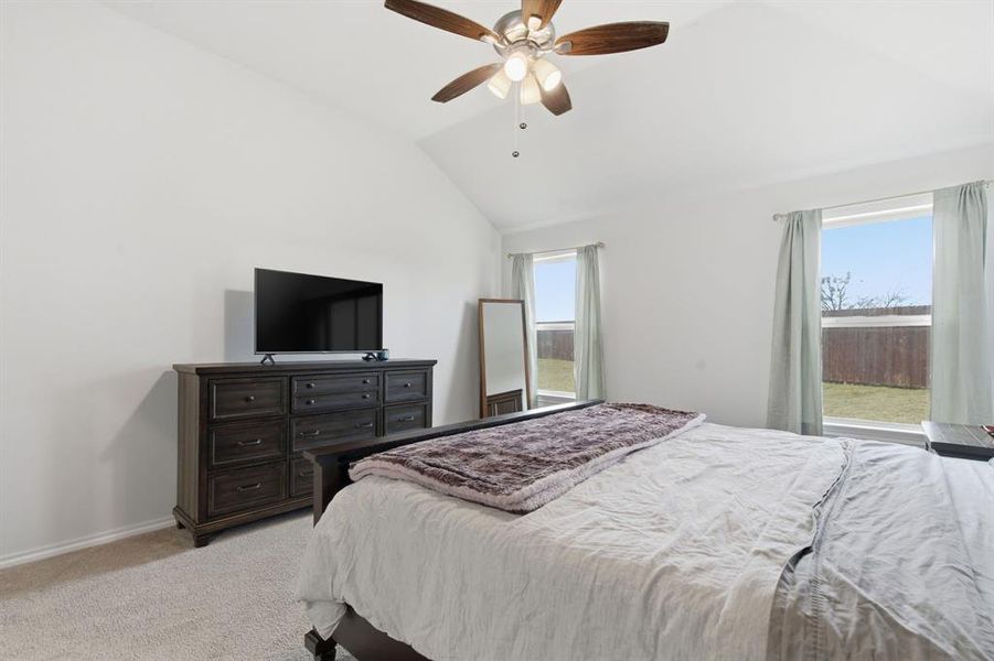 Bedroom featuring lofted ceiling, light colored carpet, and ceiling fan